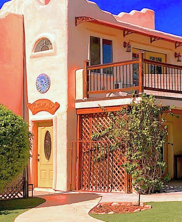 A two-story building with a balcony, a decorative door, and a small garden area. - LADIES SPA VILLA RETREAT - Cave Creek, AZ
Day Spa, Full Moon Drum Circle & Meals (Phoenix)