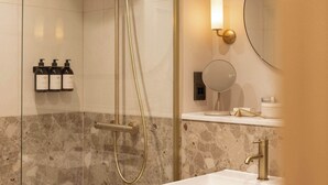 Une salle de bain moderne avec une douche, un lavabo et un miroir.