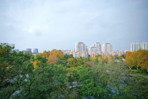 A cityscape with high-rise buildings and dense foliage in the foreground. - Xinrenren Hotel (Shanghai Daning International Zhabei Park Branch) (Shanghai)