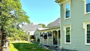 A two-story house with a porch and a well-maintained lawn.