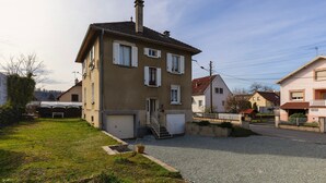 Ein zweistöckiges Haus mit Vorgarten, einem Schotterweg und einer kleinen Treppe, die zum Eingang führt.