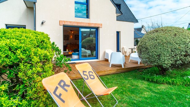 A modern house with a deck, two lounge chairs marked FR 56, and a well-maintained garden. - Ty Kéréré - Maison 3★ - Calme, Grand Jardin Arboré, 500m plage (Locmariaquer)
