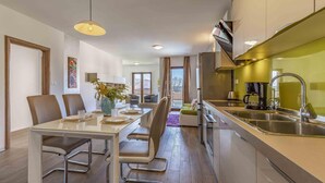 Una cocina moderna con comedor, que incluye una isla central con pileta y cafetera.