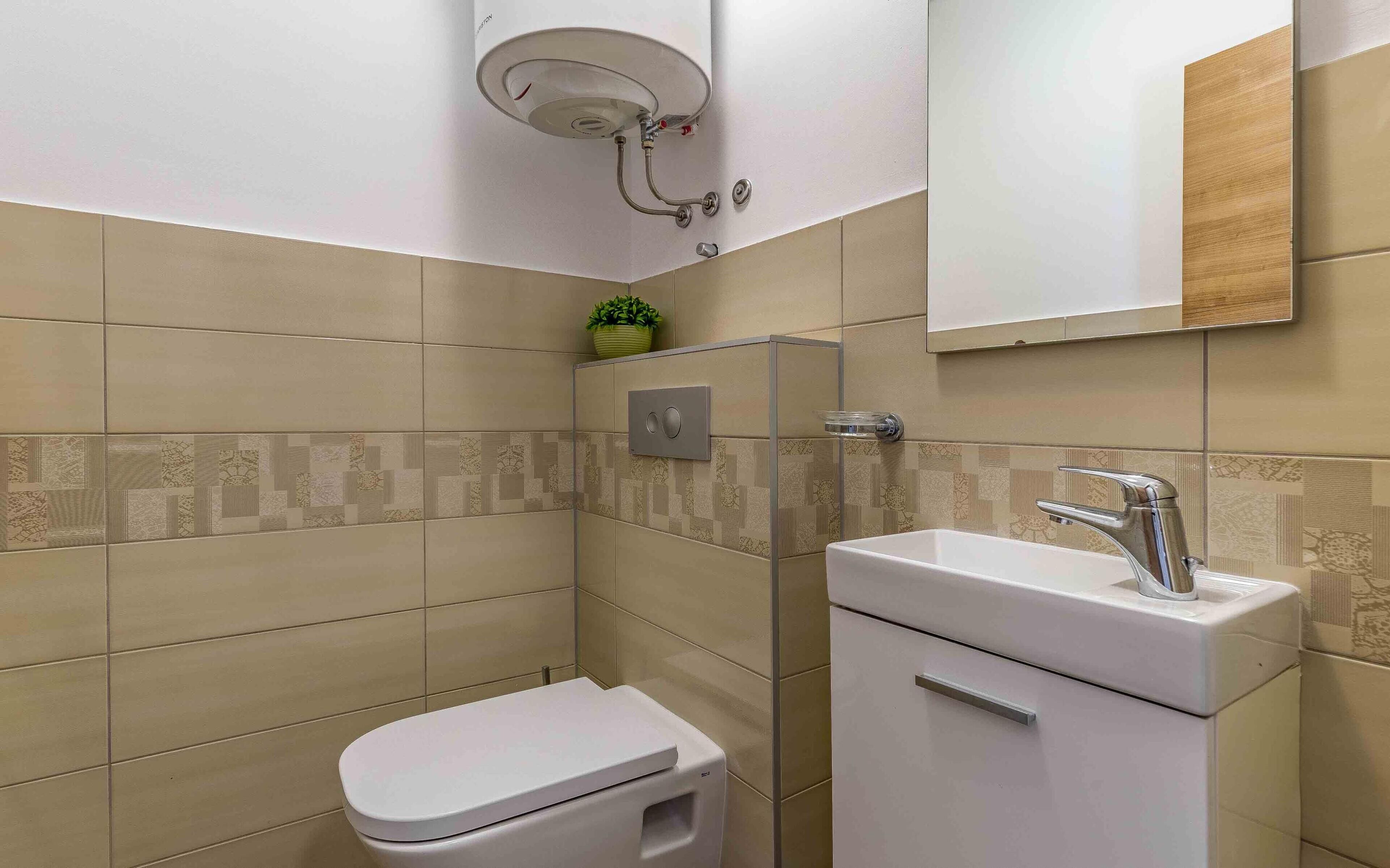 A modern bathroom with a toilet, sink, and shower.