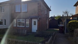 A residential house with a white front door, a brick exterior, and a small front yard. - House-sleeps 5-parking-bbq-garden-patio (Chesterfield)