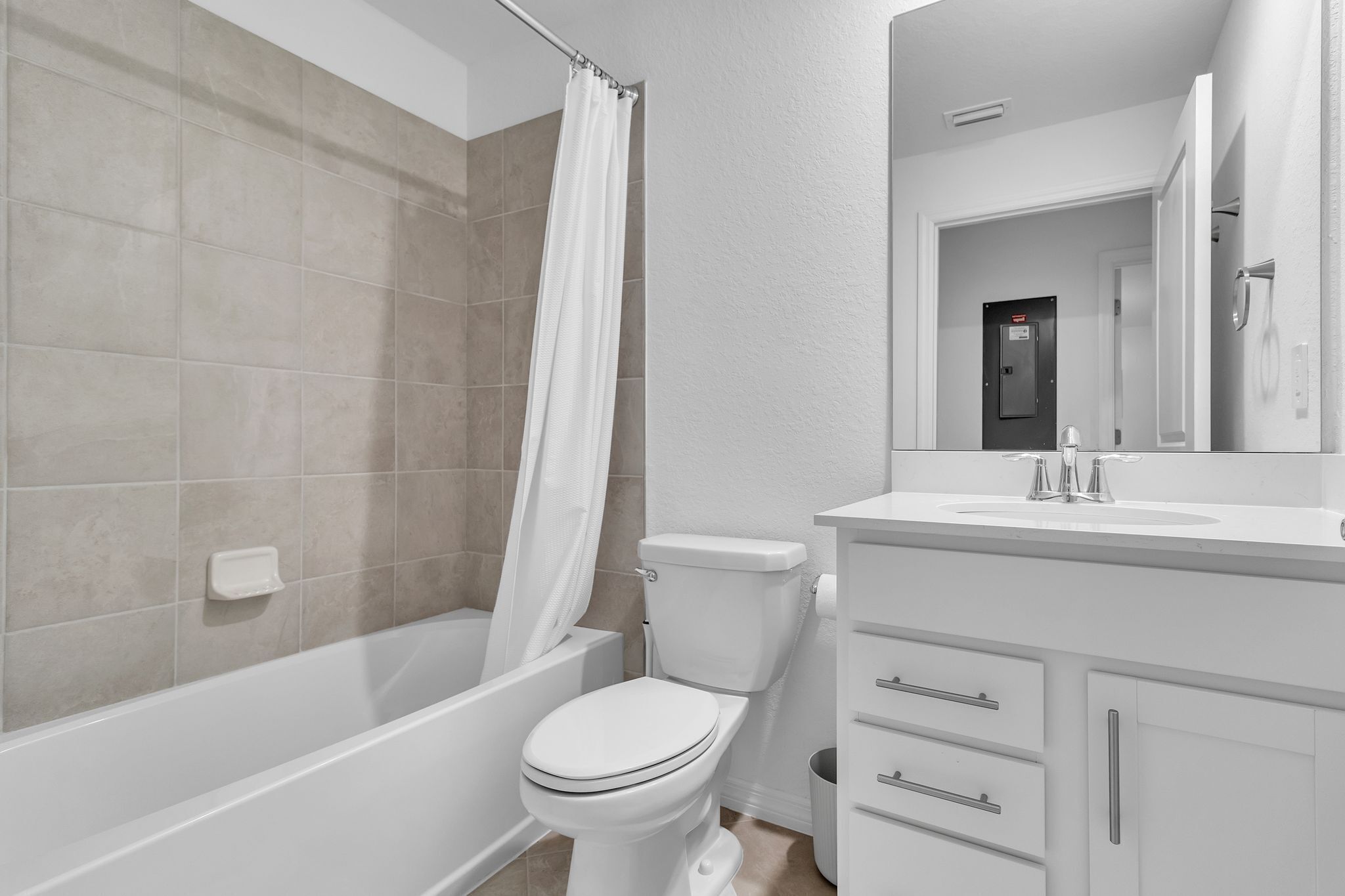 Une salle de bain moderne équipée d’une baignoire, de toilettes et d’un meuble-lavabo.