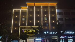 Un edificio de varios pisos con letreros iluminados y ventanas, probablemente un hotel o propiedad comercial.
