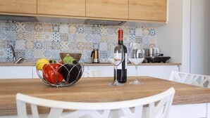 Een keuken met een houten aanrecht, een wijnfles en een schaal fruit.