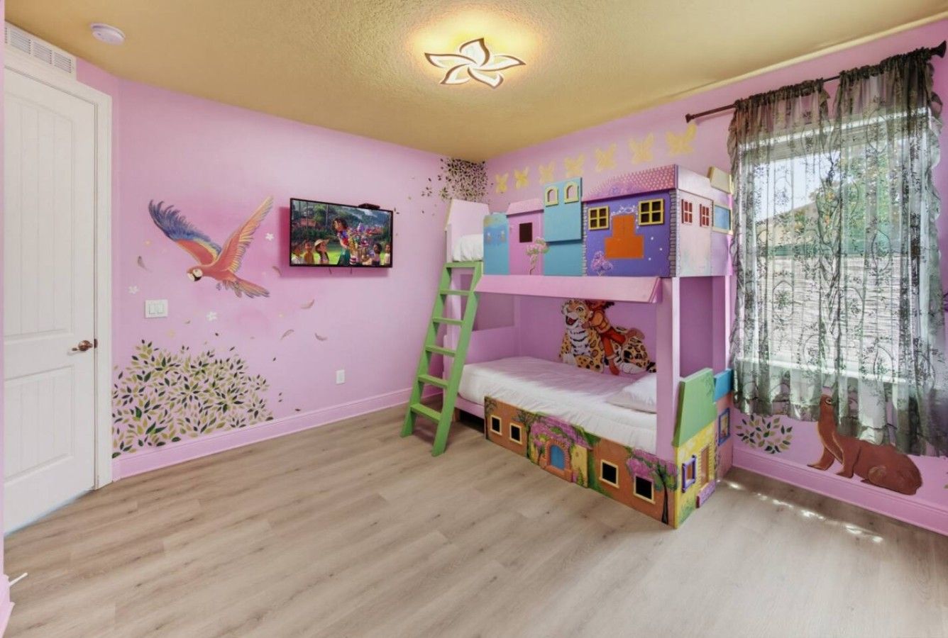 A child's bedroom with bunk beds, a ladder, and a window with curtains.