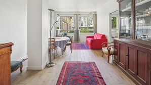 Ein geräumiges Zimmer mit Essbereich, einem roten Sofa und einer Vitrine.
