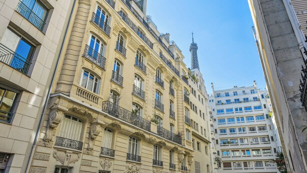 Ein mehrstöckiges Gebäude mit aufwendigen architektonischen Details, darunter dekorative Stuckleisten und Balkone mit schmiedeeisernen Geländern.