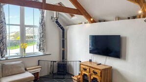 Ein gemütliches Wohnzimmer mit Kamin, Flachbildfernseher und einer bequemen Sitzecke.