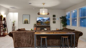 Un salon moderne avec un canapé marron, une table basse en bois et un téléviseur fixé au mur.