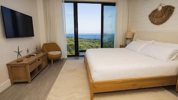 Un dormitorio con una cama grande, una mesita de noche de madera, un televisor y vistas al exterior.