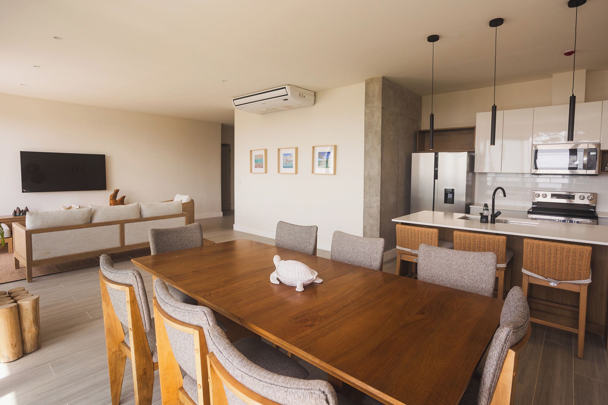 A modern kitchen with a wooden dining table, chairs, and a microwave.