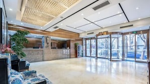 A modern lobby with a reception desk, a seating area, and a glass door entrance. - Homeinn Superior Yun Hotel (Beijing Qianmen) (Beijing)