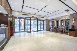 A hotel lobby with a revolving door, reception desk, and seating area. - Homeinn Superior Yun Hotel (Beijing Qianmen) (Beijing)