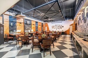 A restaurant with a checkered floor, wooden walls, and a ceiling fan. Tables and chairs are arranged for dining. - Homeinn Superior Yun Hotel (Beijing Qianmen) (Beijing)