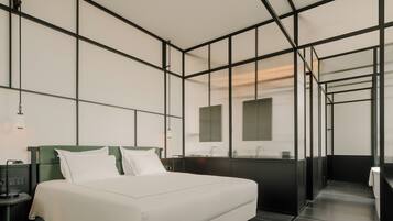 Une chambre d’hôtel moderne avec un grand lit, un bureau et un miroir.