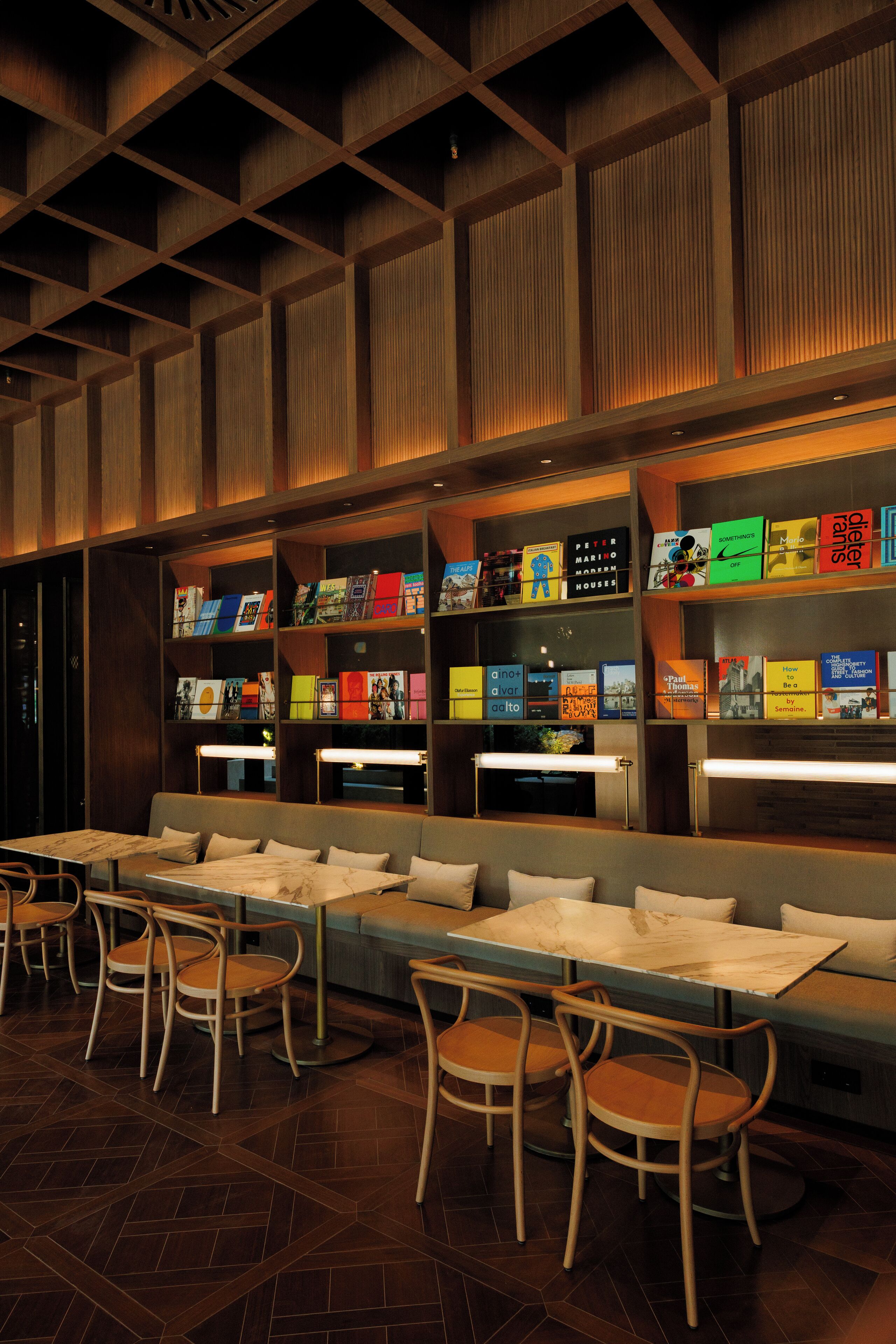 A modern library with bookshelves, seating, and tables.