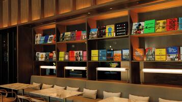 A modern library with bookshelves, seating, and tables.