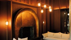 Un interno moderno con camino, pannelli in legno e un divano.