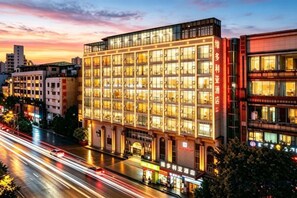 Un hôtel à plusieurs étages, doté d’une façade moderne, de grandes fenêtres et d’une entrée imposante.