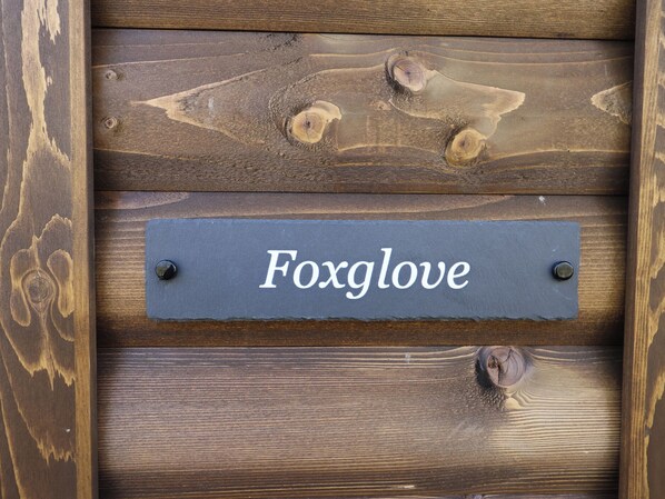 En träskylt med namnet ”Foxglove” monterad på en vägg.