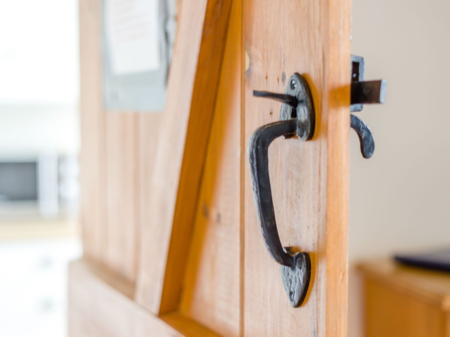 Une porte en bois avec une poignée en métal et un loquet.