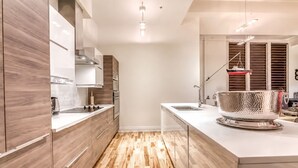 Una cocina moderna con armarios de madera, un lavamanos de acero inoxidable y suelo de madera.