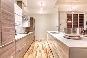 Eine moderne Küche mit Holzschränken, einer Edelstahl-Spüle und einem Holzboden.
