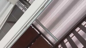 A modern interior with a glass and metal staircase, white walls, and a patterned floor. - Central Station House (Naples)