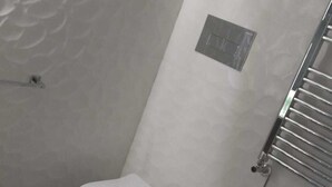 A compact bathroom with a toilet, bidet, and a small shelf with toiletries. - Central Station House (Naples)