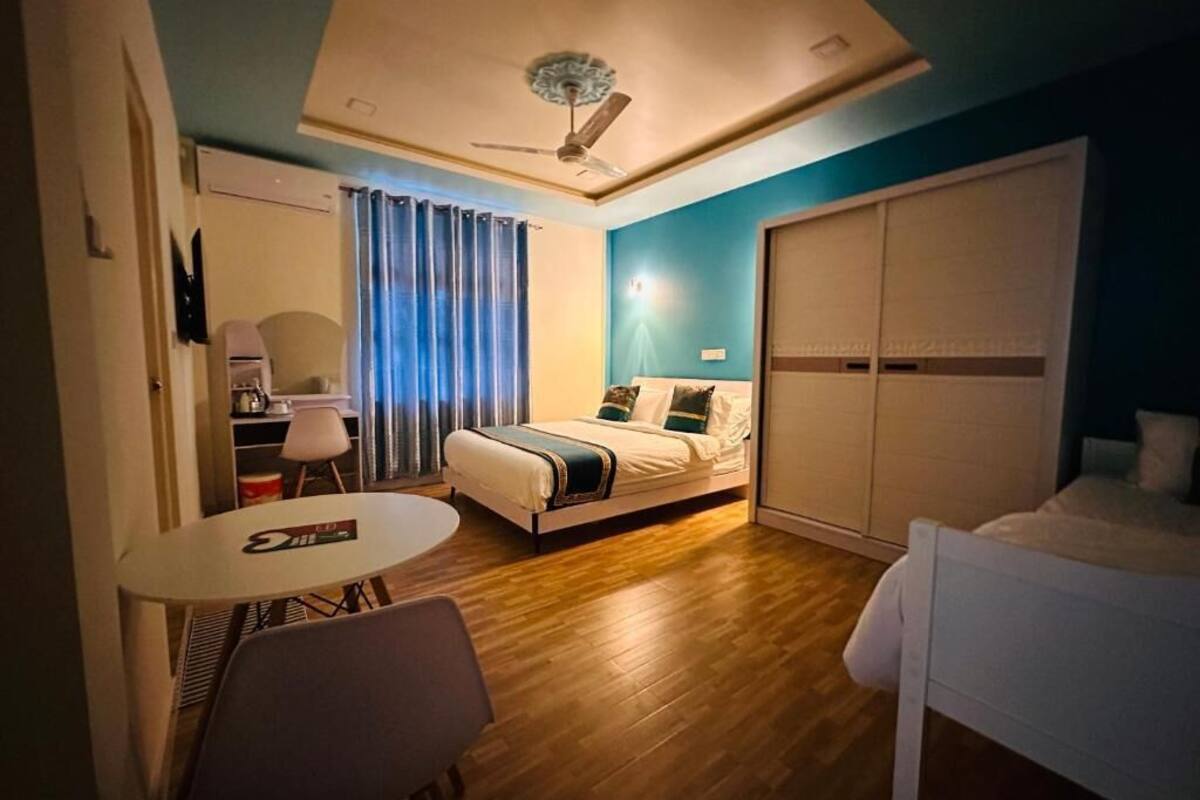 Un dormitorio con cama, escritorio, silla y ventilador de techo.