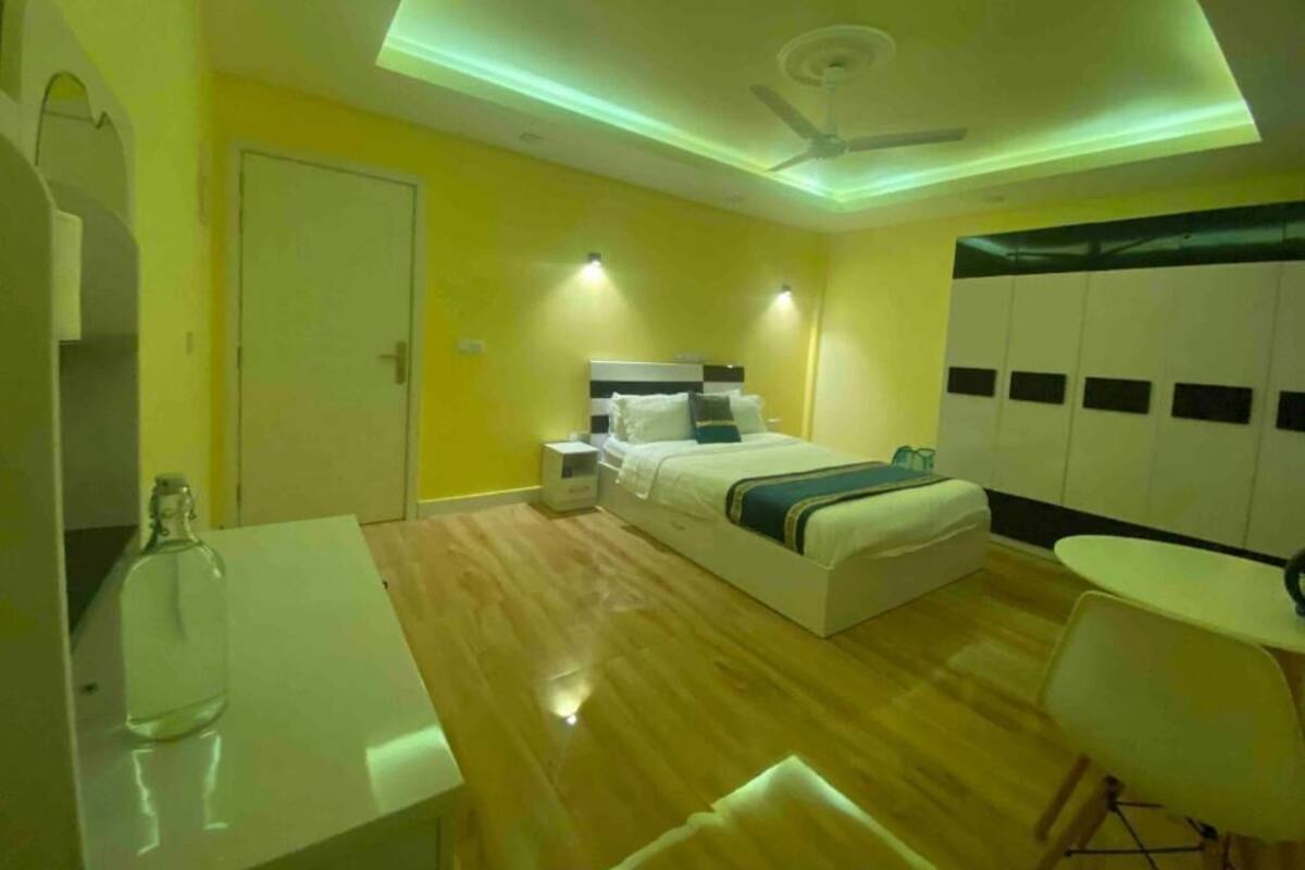 Un dormitorio moderno con cama, mesitas de noche, escritorio y silla.