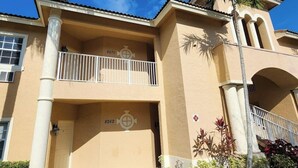 A building with balconies, a palm tree, and a door with the number 8262. - Right Direction Rentals Studio Villa 8270 (Port St. Lucie)