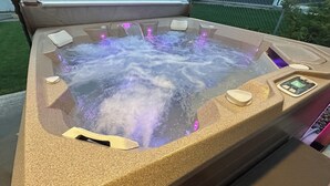 A hot tub with a textured surface, built-in controls, and a water pump. - Spacious 5-bedroom house in beautiful Anaconda with Salt water Hot Tub (Anaconda)