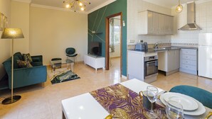 A modern apartment with a living room, dining area, and kitchen.