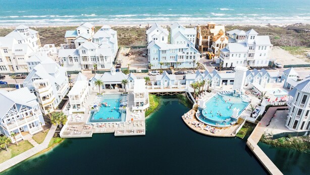 A coastal resort with multiple swimming pools, a dock, and beachfront views. - Dune Alright 206 PLA (Port Aransas)