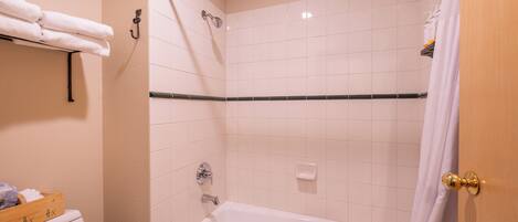 Un baño con bañera, ducha y retrete.