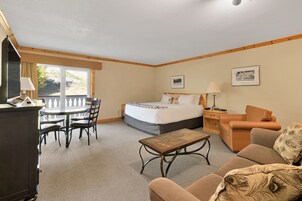Una habitación de hotel con una cama, un escritorio, una silla, un sofá y una mesita.