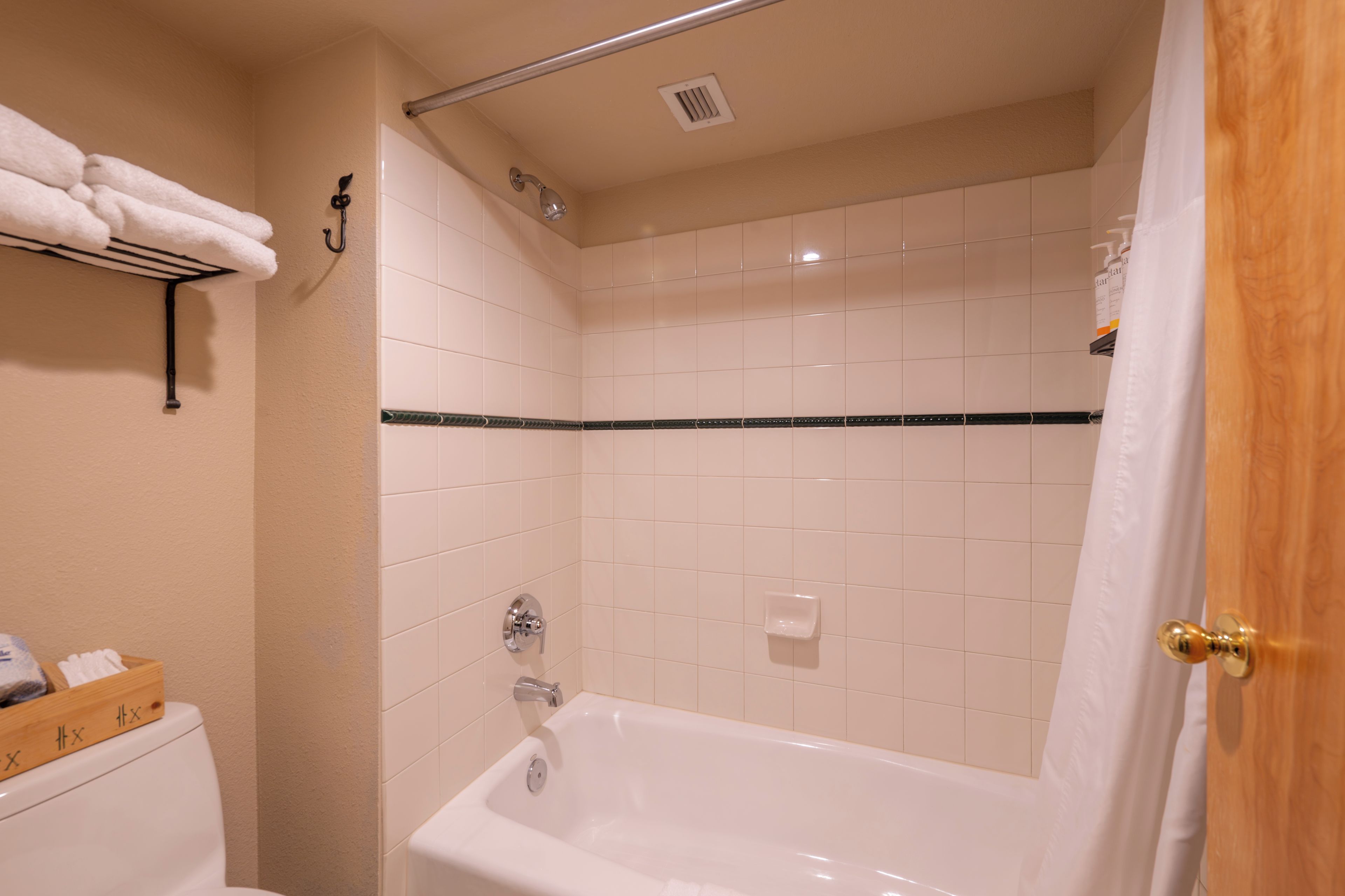 A bathroom with a bathtub, a toilet, and a shower area.