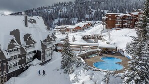 Une station de ski comprenant plusieurs bâtiments, un espace piscine et des environs enneigés.