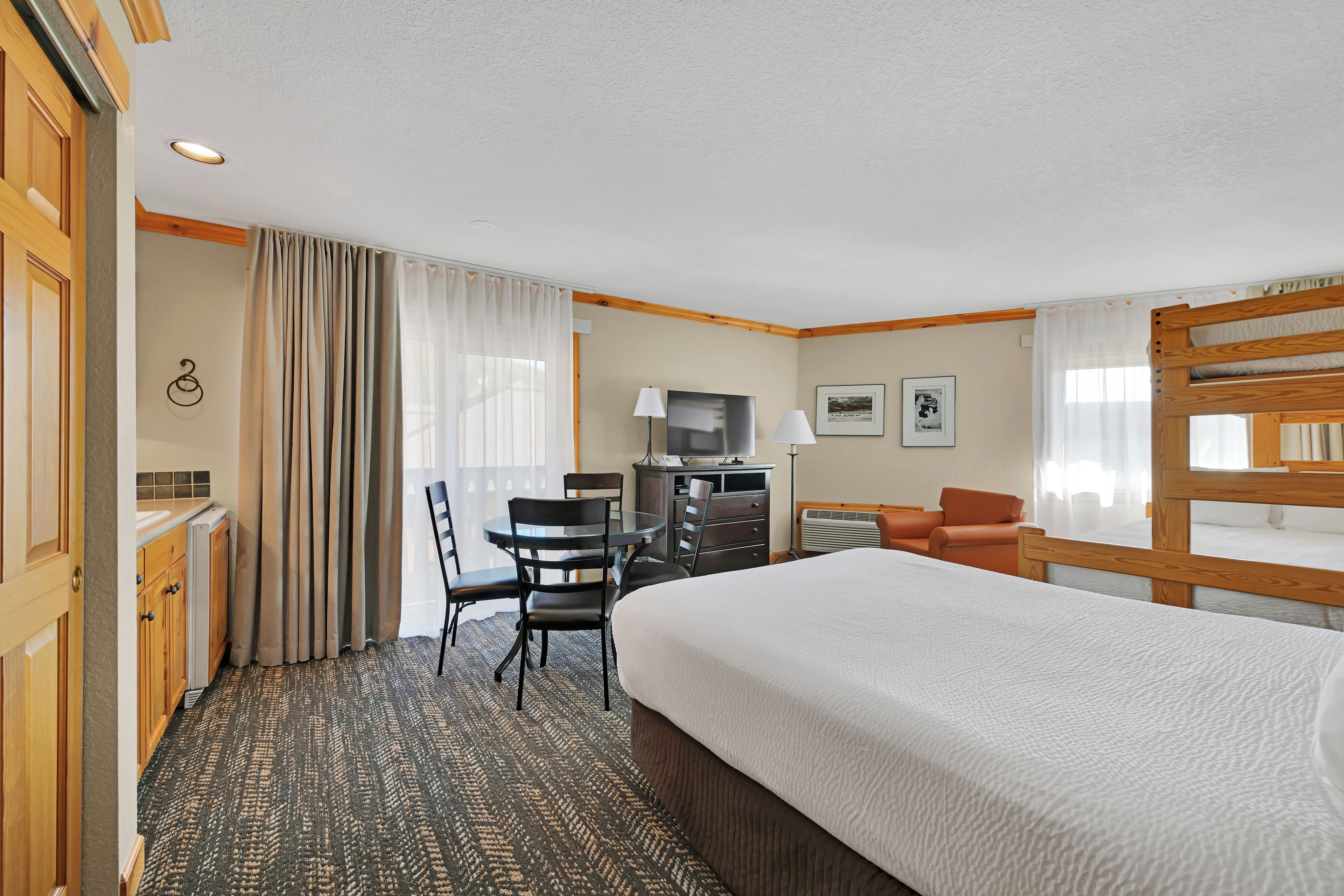 Une chambre d’hôtel avec un grand lit, un bureau avec une chaise, une télévision et un canapé.