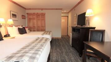 A hotel room with a bed, a desk, a television, and a wardrobe.