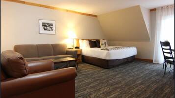 Een hotelkamer met een bed, een bank, een bureau en een stoel.