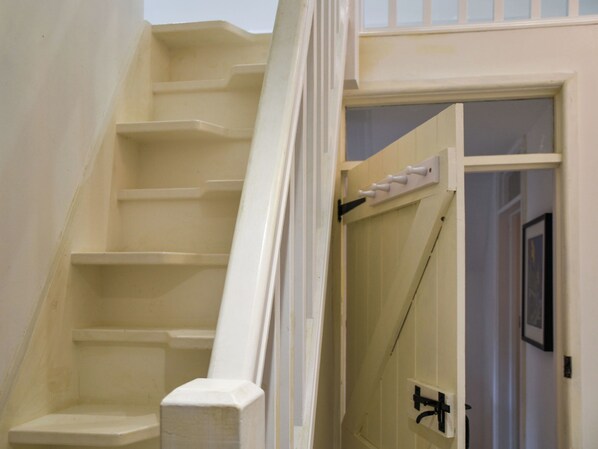 A staircase with a white handrail leading to a landing.