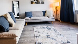 A modern living room with a sofa set, a rug, a painting, and a lamp. - Spacious 4 Bed with Free Parking (Southampton)