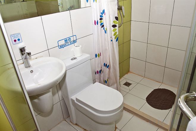 A bathroom with a sink, toilet, and shower area.