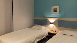 A twin room with two single beds, a nightstand with a lamp, and a framed picture on the wall. - 100 Inn Shanghai Songjiang Xincheng Subway Station (Shanghai)